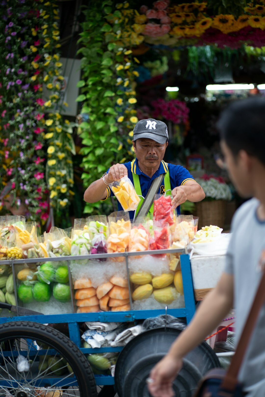 Local market vendor arranging vegetables at a Danish market stall